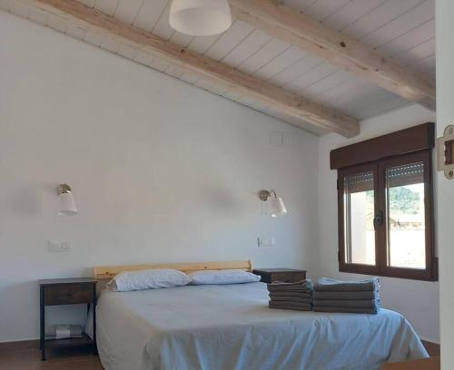 a white bedroom with a large bed with a window at Casa rural La Azuleja de Alatoz in Alatoz