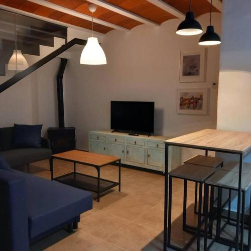 a living room with a couch and a tv at Casa rural La Azuleja de Alatoz in Alatoz
