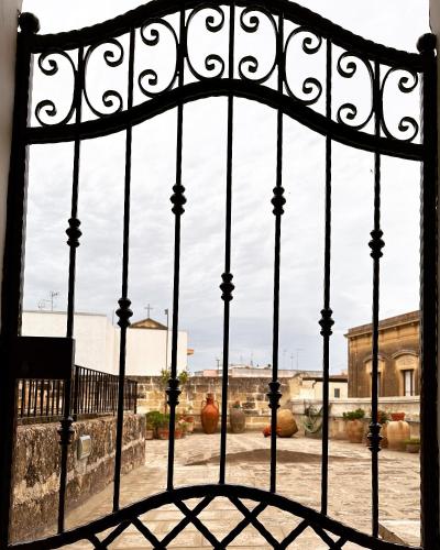 an iron gate with a view of a courtyard at La Dimora Del Barone in Vernole