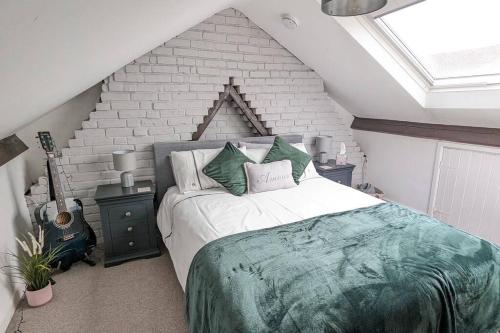 - une chambre avec un grand lit et un mur en briques dans l'établissement Stunning Victorian Terrace in the Golden Triangle, à Norwich