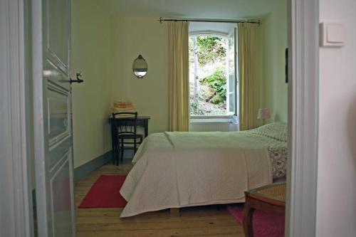 um quarto com uma cama e uma janela em Notre-Dame d'Escouloubre em Escouloubre
