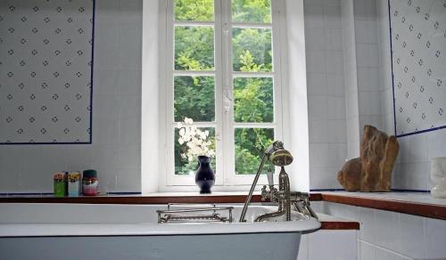 a bath tub in a kitchen with a window at Notre-Dame d'Escouloubre in Escouloubre