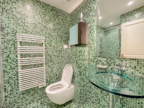 La salle de bains est pourvue de toilettes et d'un lavabo en verre. dans l'établissement Sea view Marina Baie des Anges luxury apartment, à Villeneuve-Loubet