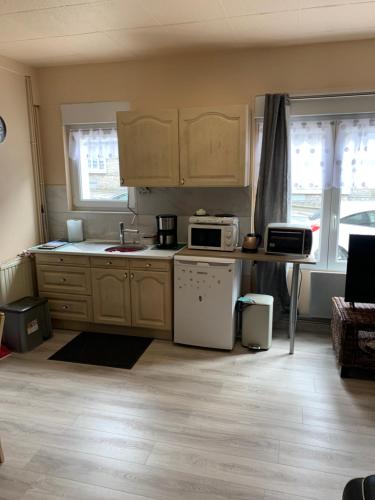 - une cuisine avec des placards en bois et des appareils blancs dans l'établissement Chez François, à Boulogne-sur-Mer