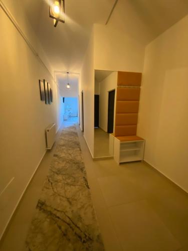 un corridoio con un lungo corridoio con un tappeto di Mr&Mrs ApartHotel a Fălticeni