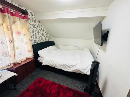 a small bedroom with a bed and a television at Unique private rooms (1) in Bolton