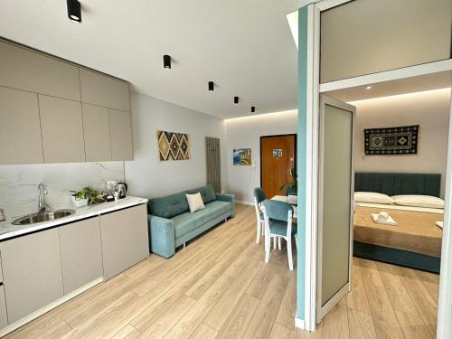 eine Küche und ein Wohnzimmer mit einem Sofa und einem Bett in der Unterkunft TreA Accomodations - Despacito TRB Sea View in Vlorë
