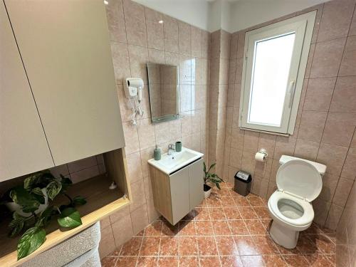 ein Bad mit einem WC, einem Waschbecken und einem Fenster in der Unterkunft TreA Accomodations - Despacito TRB Sea View in Vlorë