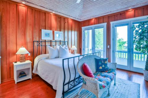 a bedroom with a bed and a chair and windows at ROOSEVELT COTTAGE in Captiva
