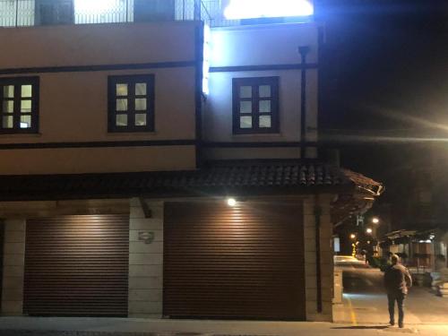 a man standing in front of a building at night at ESER PALAS OTELİ in Konya