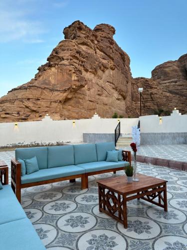 une terrasse avec un canapé bleu et une table dans l'établissement منتجع مرايا, à Al-Ula