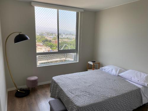 a bedroom with a bed and a large window at Habitación en miraflores in Lima