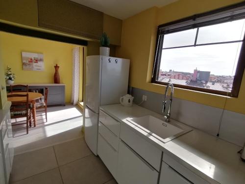 une cuisine avec un réfrigérateur blanc et une fenêtre dans l'établissement Le Panoramic, à Toulouse