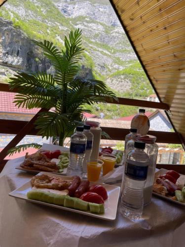 uma mesa coberta com pratos de comida e garrafas de água em Guest house RIREYIANA em Tamarë