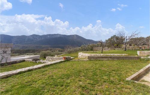 a field of grass with mountains in the background at 1 Bedroom Amazing Apartment In Podgrade in Slime