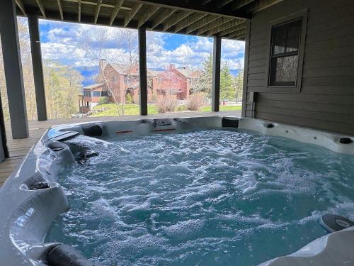 eine Whirlpool-Badewanne in einem Haus mit großem Fenster in der Unterkunft P5 Ski-in Ski-out rare find Presidential View single family with garage pool table ping pong in Carroll