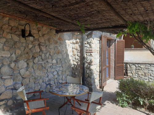 a table and chairs in front of a stone wall at Borgo di Monte Murlo in Guardistallo