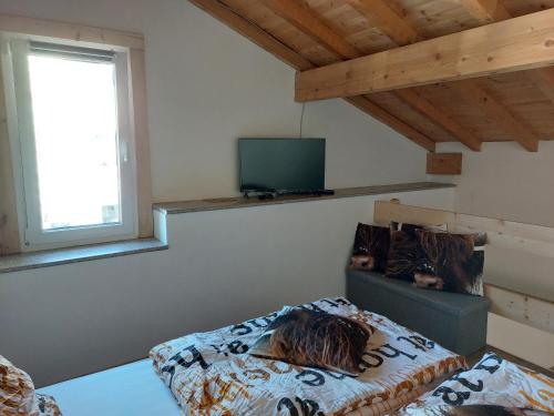 a bedroom with a bed and a tv on the wall at Gite de Moulin Maurt 1 in Xertigny