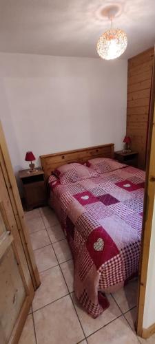 une chambre avec un lit et un lustre dans l'établissement Coquet F2 La Giettaz avec garage vélos/motos, à La Giettaz