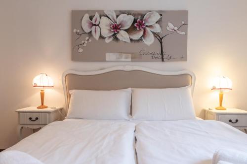 a bedroom with a white bed with two lamps at Residence Ledro in Ledro