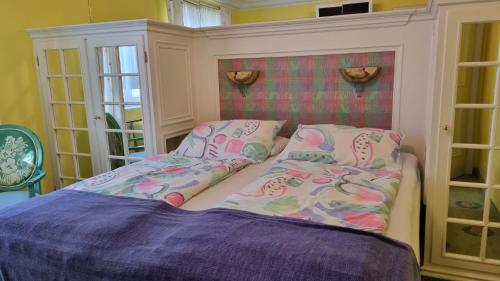 a small bedroom with a bed and pillows at Boutique Hotel Villa am See in Hagnau