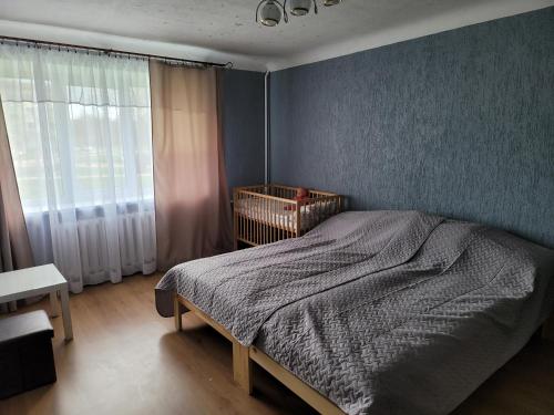 a bedroom with a bed and a window with a crib at SMILE in Ventspils