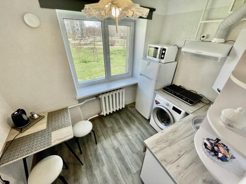 a small kitchen with a refrigerator and a window at SMILE in Ventspils