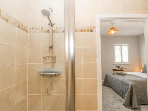 a bathroom with a shower and a bed in a room at Sea La Vie in Benllech
