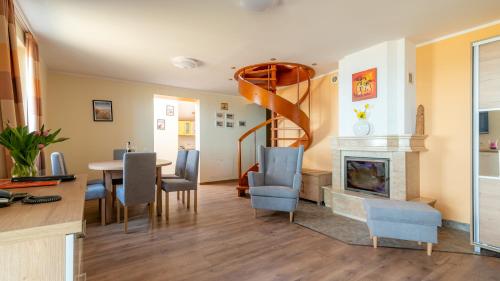a living room with a table and chairs and a spiral staircase at Ledan in Chłopy
