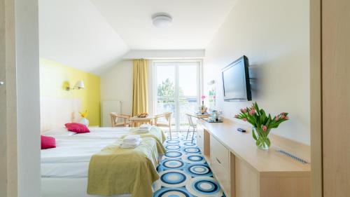 ein Hotelzimmer mit einem großen Bett und einem Schreibtisch in der Unterkunft Ledan in Chłopy