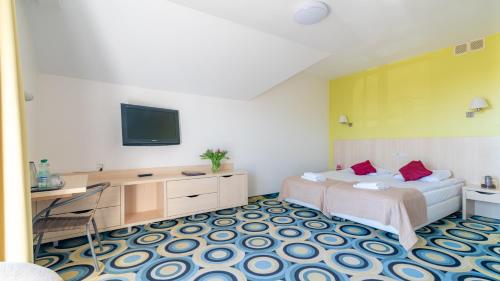 a bedroom with a bed and a tv on the wall at Ledan in Chłopy