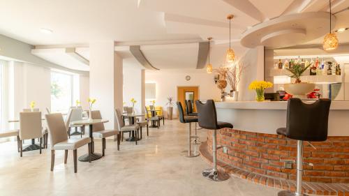 a restaurant with a bar with chairs and tables at Ledan in Chłopy