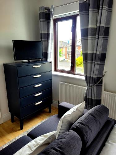 un soggiorno con divano, cassettiera e finestra di Grange House B&B a Galway