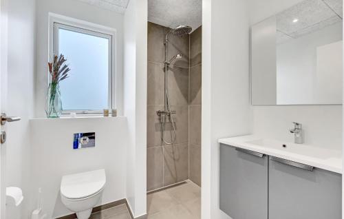 uma casa de banho branca com um WC e um lavatório em 4 Bedroom Awesome Home In Lgstrup em Løgstrup