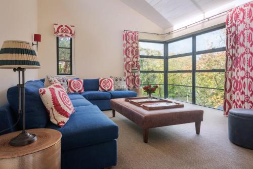 a living room with a blue couch and a table at Goodshelter Bay in Salcombe