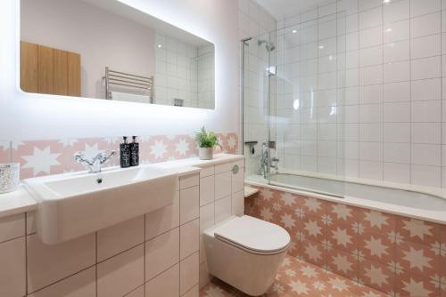 a bathroom with a sink and a toilet and a tub at Goodshelter Bay in Salcombe