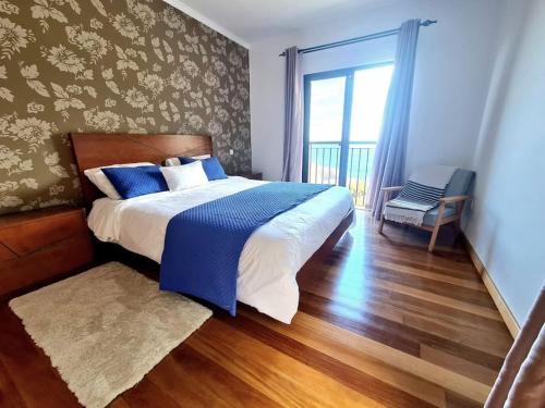 a bedroom with a bed with blue and white sheets at Casa da Portada in Seixal