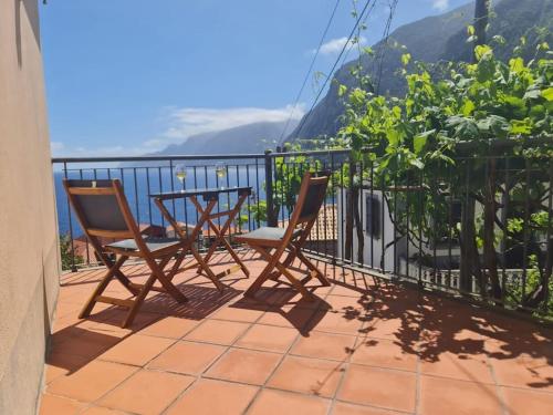 a patio with two chairs and a table on a balcony at Casa da Portada in Seixal