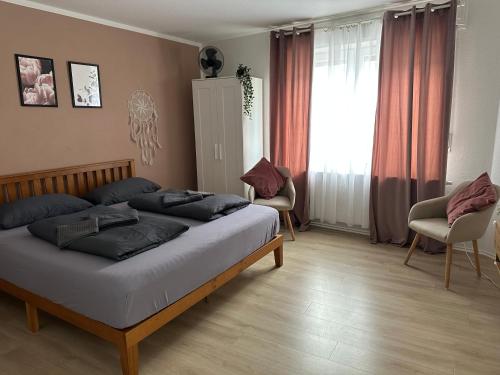 a bedroom with a bed and two chairs and a window at Rooms4ring UG Romantic Bohemian Apartment Adenau in Adenau