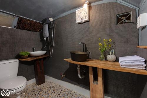 een badkamer met een wastafel en een toilet in een kamer bij Tiệm Cà Phê Mer Homestay & Coffee Mộc Châu in Mộc Châu