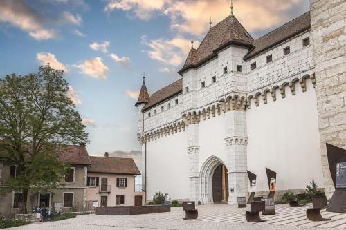 un grand bâtiment blanc avec une tour d'horloge dans l'établissement Le Tresum - Studio near Annecy Lake, à Annecy