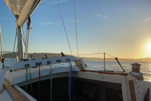 a boat on the water with the sun in the background at O Cerrulo Apartamento céntrico Pontedeume in Puentedeume
