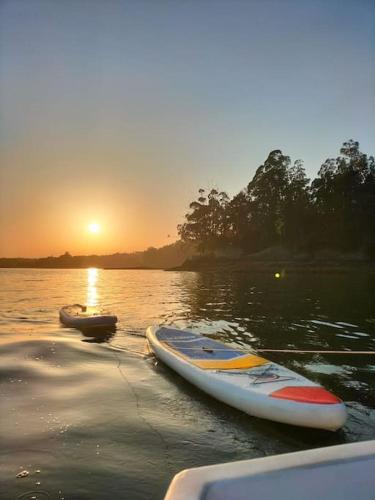 a couple of boats sitting in the water at sunset at O Cerrulo Apartamento céntrico Pontedeume in Puentedeume