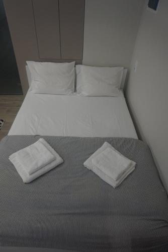 a bed with two white towels on top of it at Vasili's and Vasiliki's luxury apartment in Athens