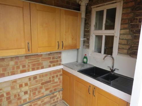 a kitchen with a sink and a brick wall at 31 Elwyn Snug in March