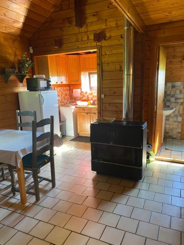 a kitchen with a table and a stove in a room at Maison 2 chambres proche Dijon chalet niché dans la nature in Saint-Maurice-sur-Vingeanne