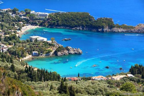 a view of a beach with blue water and trees at Vanilla House Paleokastritsa in Paleokastritsa