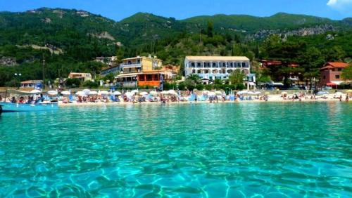 a group of people on a beach with the water at Vanilla House Paleokastritsa in Paleokastritsa