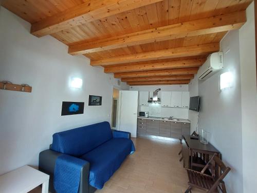a living room with a blue couch and a kitchen at Pizzocolo resort fasano in Gardone Riviera