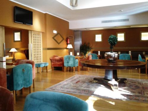 a living room with a table and chairs and a tv at Hotel Central Parque in Maia
